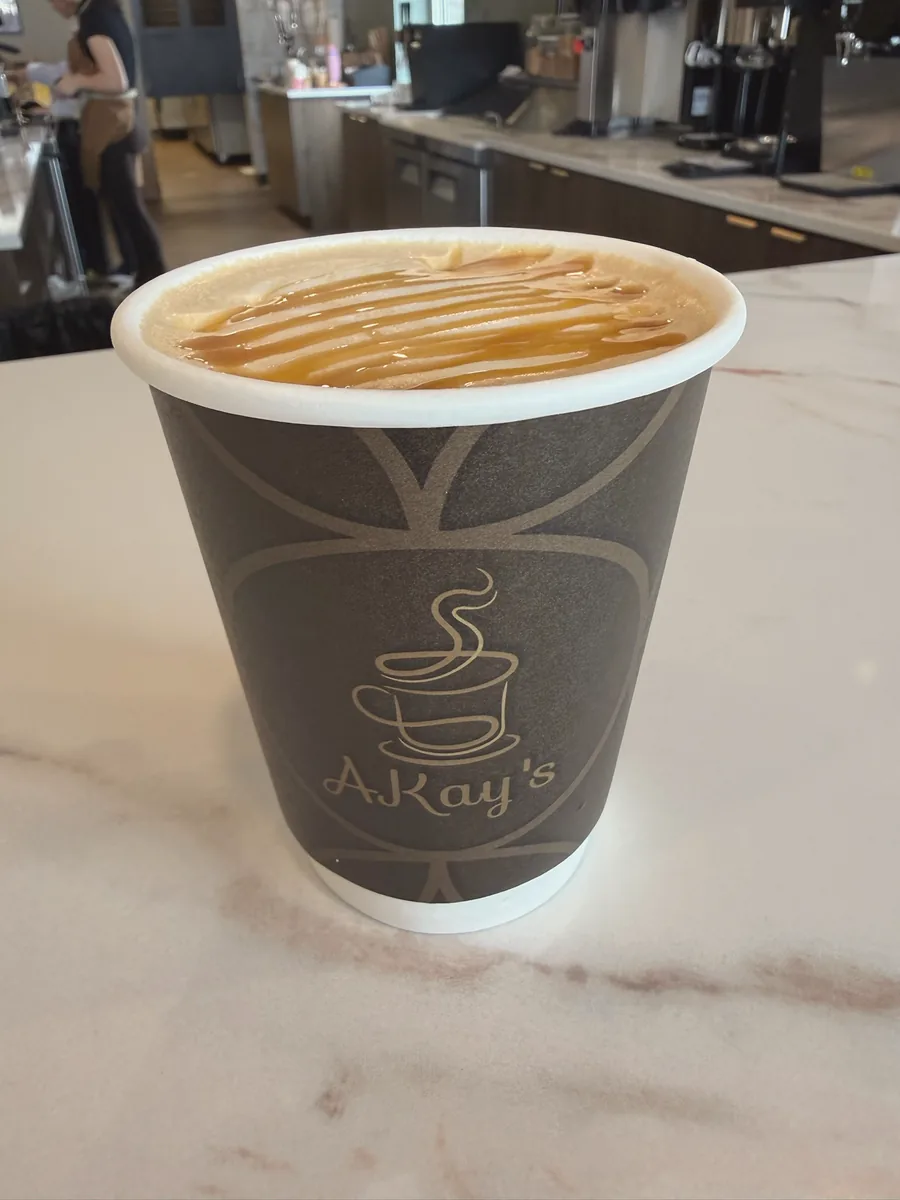 AKay's Coffee latte in a branded cup